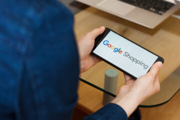 kvinna med telefon, text Google shopping på skärmen